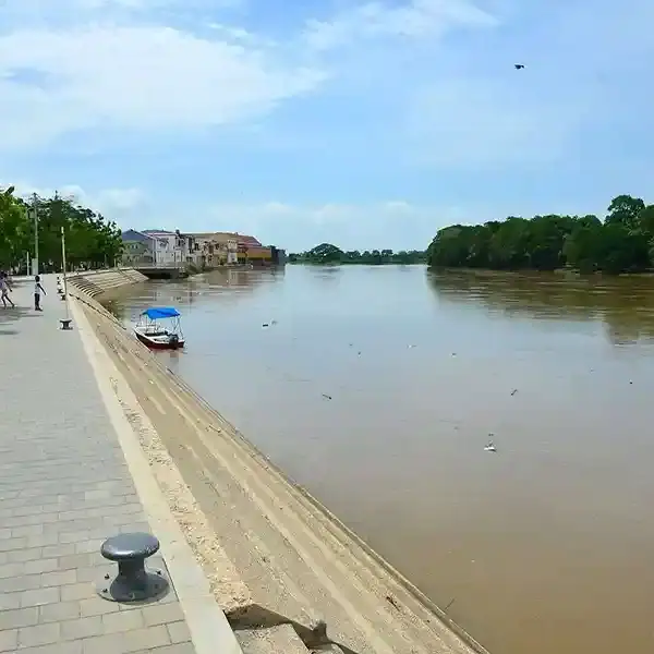 Borde del río Lorica con paseo peatonal y árboles verdes en Córdoba, Colombia.