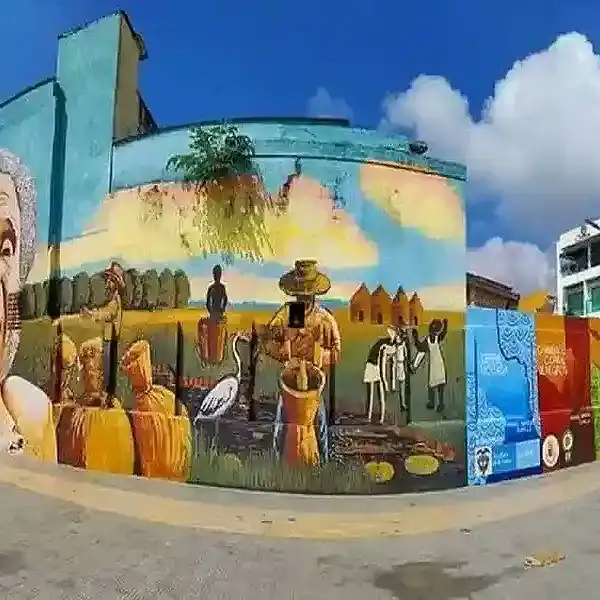 Pared con mural colorido que representa escenas culturales y rurales de Lorica, Córdoba, Colombia.