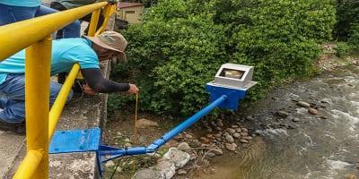 Clima 3 Persona revisando medidor de agua junto al río en Lorica, Córdoba.