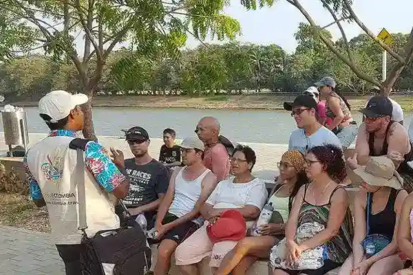 Guía turístico explicando detalles a un grupo de visitantes junto al río.