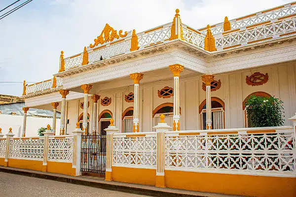 Gremios 5 Casa colonial en Lorica, Córdoba, Colombia, con detalles en blanco y amarillo.